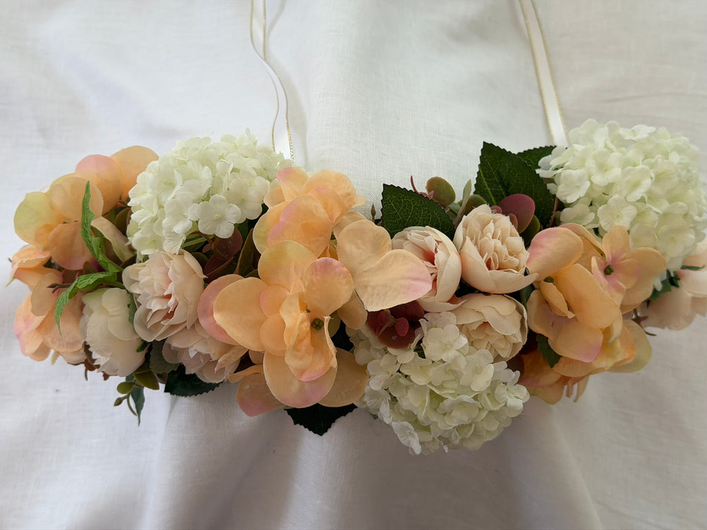 Full, lush floral design Peach hydrangea, ivory hydrangea & blush garden rose blooms Lush green foliage accents Ribbon ties for adjustable, comfortable fit Wear as a flower crown, or drape as a garland Suitable for adults, children & pets. Perfect for weddings, garden parties, hens celebrations, festivals, and photoshoots