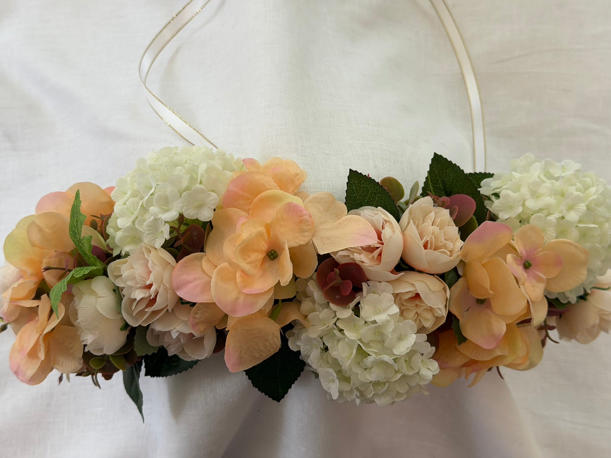 Full, lush floral design Peach hydrangea, ivory hydrangea & blush garden rose blooms Lush green foliage accents Ribbon ties for adjustable, comfortable fit Wear as a flower crown, or drape as a garland Suitable for adults, children & pets. Perfect for weddings, garden parties, hens celebrations, festivals, and photoshoots