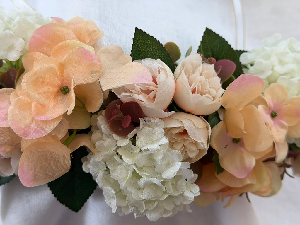 Full, lush floral design Peach hydrangea, ivory hydrangea & blush garden rose blooms Lush green foliage accents Ribbon ties for adjustable, comfortable fit Wear as a flower crown, or drape as a garland Suitable for adults, children & pets. Perfect for weddings, garden parties, hens celebrations, festivals, and photoshoots