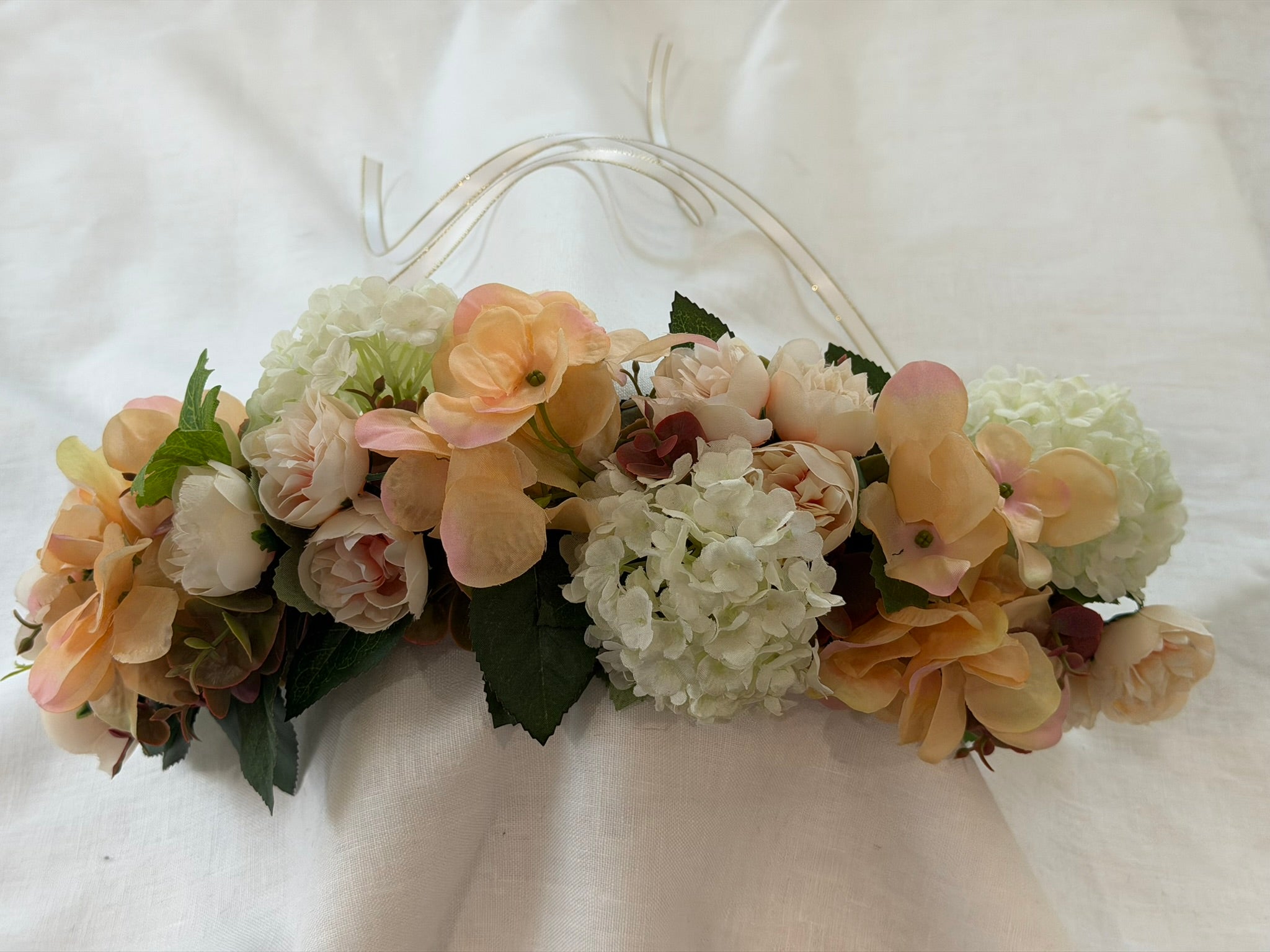 Full, lush floral design Peach hydrangea, ivory hydrangea & blush garden rose blooms Lush green foliage accents Ribbon ties for adjustable, comfortable fit Wear as a flower crown, or drape as a garland Suitable for adults, children & pets. Perfect for weddings, garden parties, hens celebrations, festivals, and photoshoots