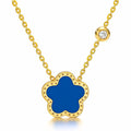 The Velvet Grove floral pendant necklace featuring a deep blue flower charm in a gold-tone frame with a crystal accent.