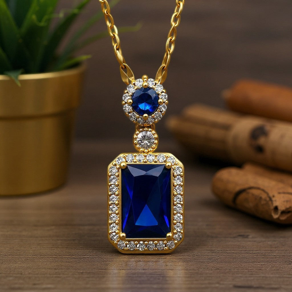 The Velvet Grove rectangular blue gemstone pendant necklace with white crystal halo and gold-tone chain.