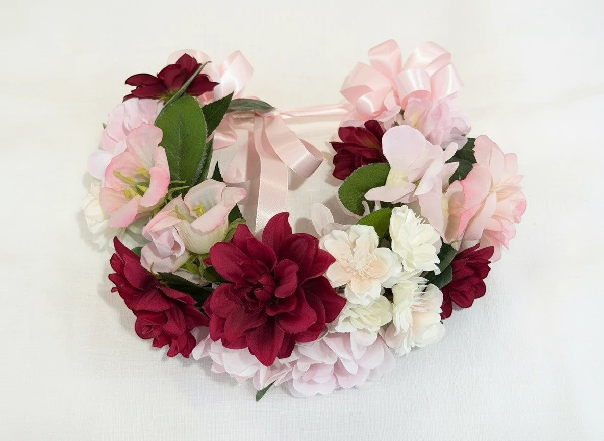 The Velvet Grove burgundy dahlia and pink bellflower floral crown with green foliage and adjustable ribbon ties.
