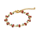The Velvet Grove gold-tone link chain bracelet featuring red enamel cherry motifs with green leaves.
