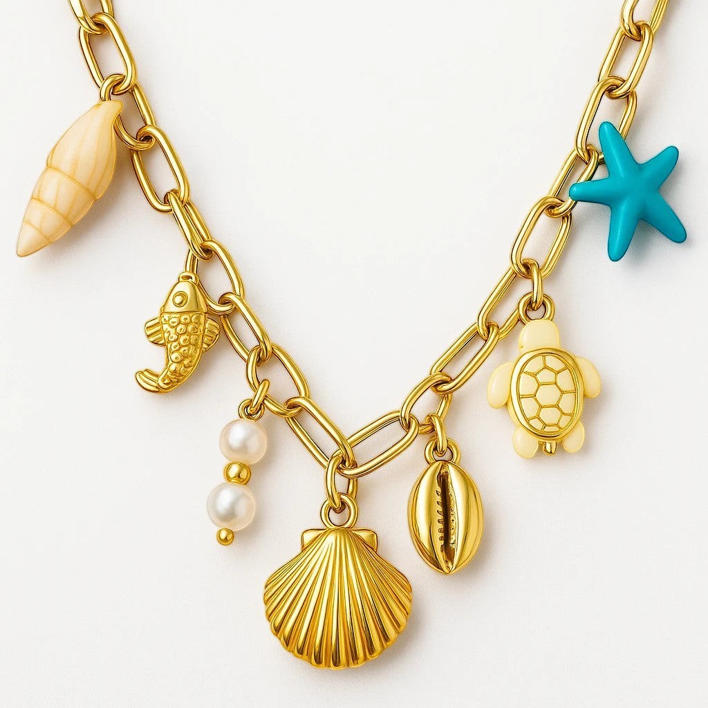 The Velvet Grove gold-tone link necklace featuring seashell, starfish, turtle, and pearl charms for a coastal look.