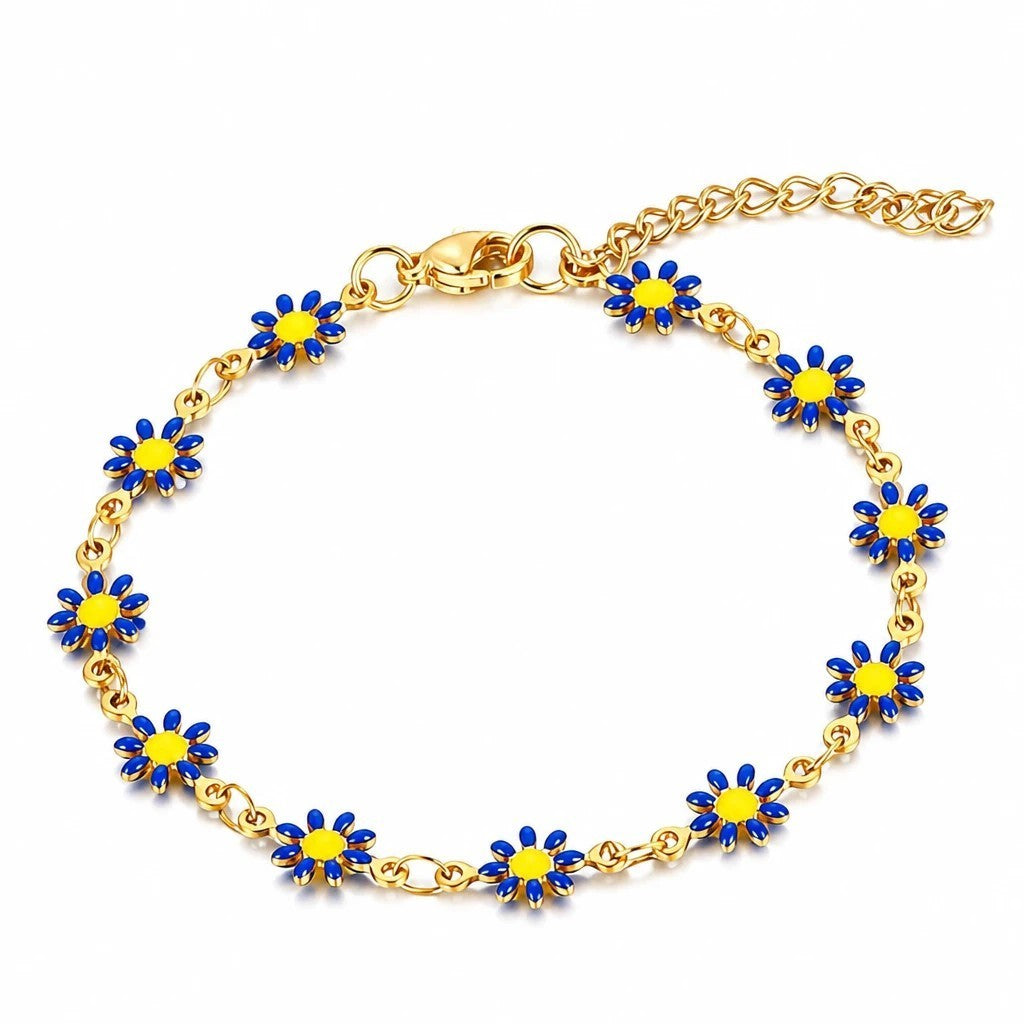 The Velvet Grove gold-tone chain bracelet featuring vibrant blue and yellow enamel daisy flower charms.