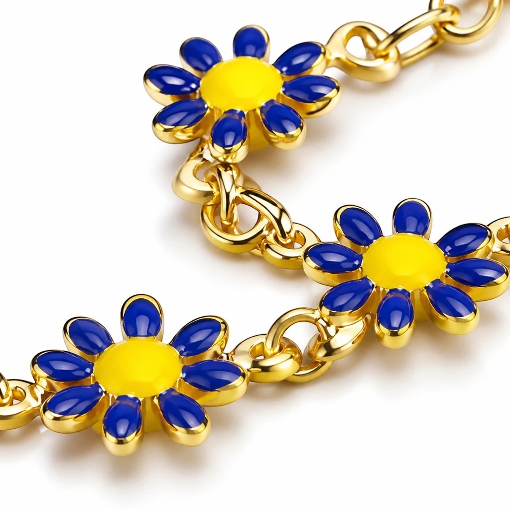 The Velvet Grove gold-tone chain bracelet featuring daisy charms with blue enamel petals and yellow centers.