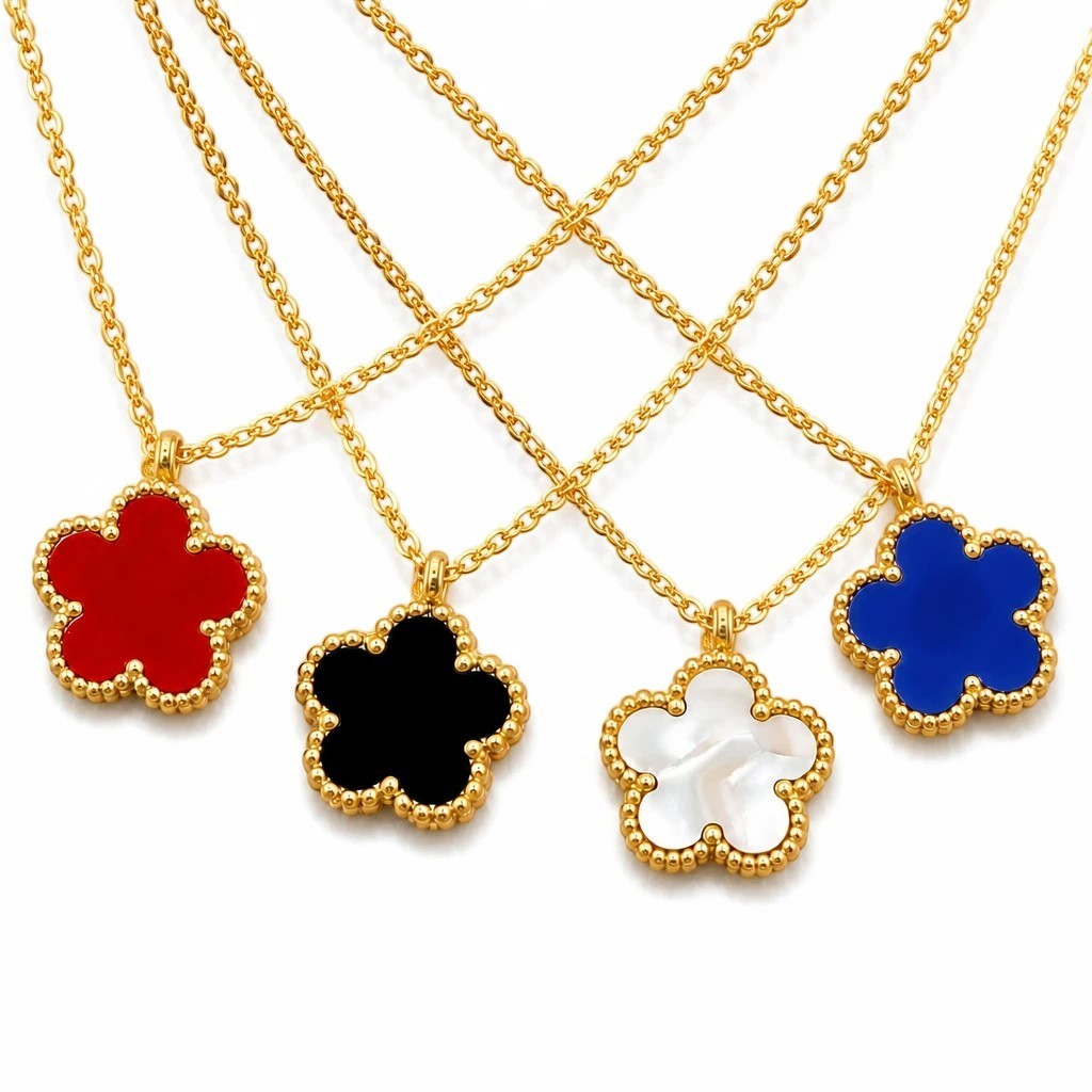 The Velvet Grove floral pendant necklaces in red, black, white, and blue with gold-tone beaded borders and chains.