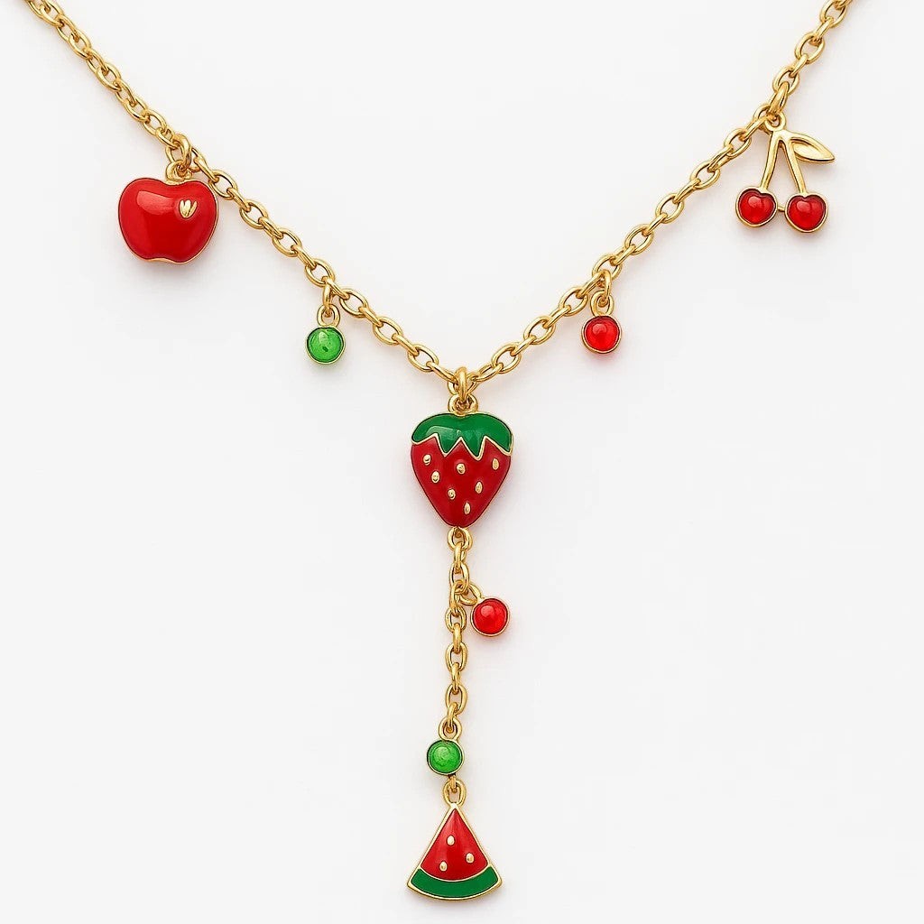 The Velvet Grove gold-tone layered necklace featuring vibrant enamel fruit charms including apple, strawberry, and cherry.
