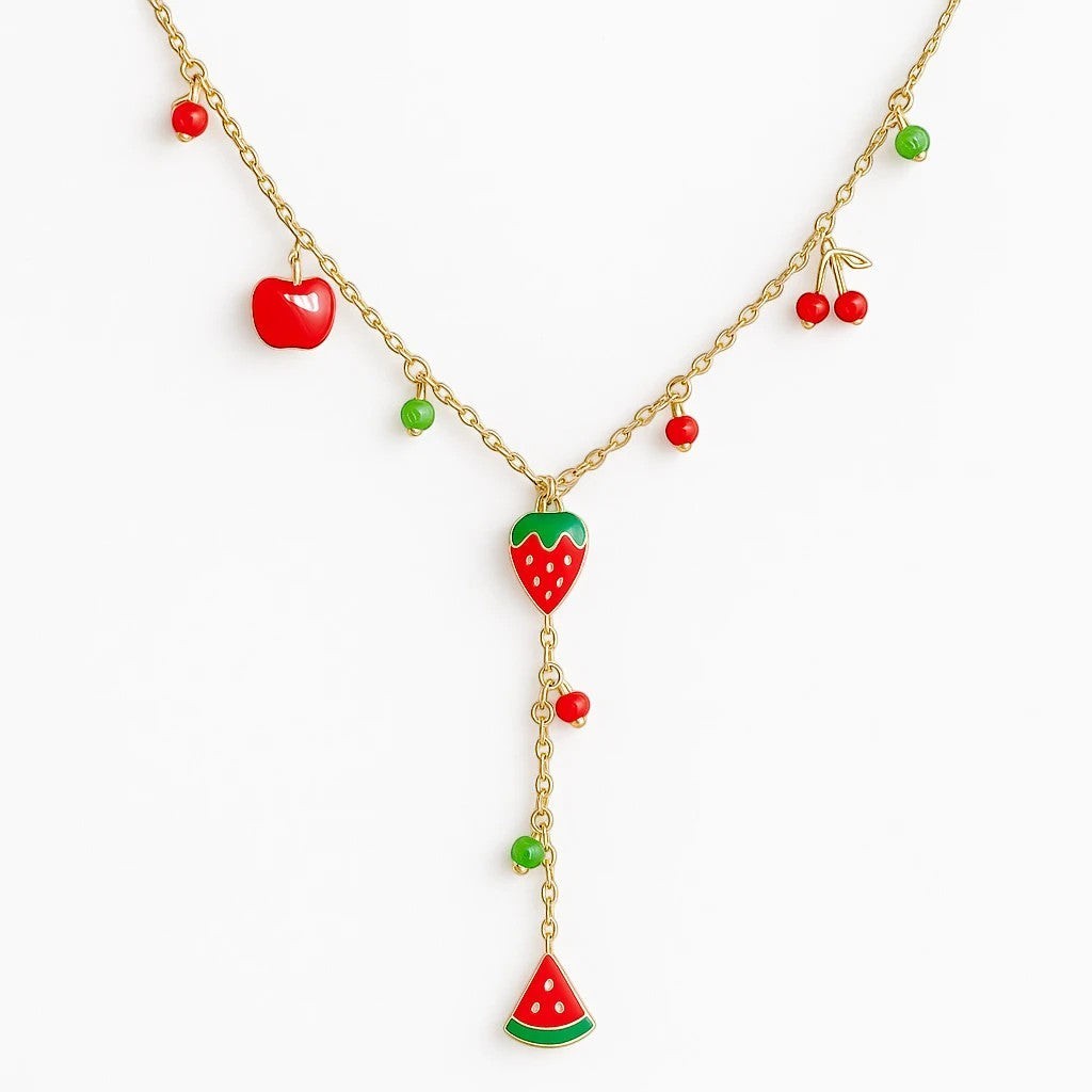 The Velvet Grove layered gold-tone necklace featuring vibrant enamel fruit charms like strawberries and cherries.