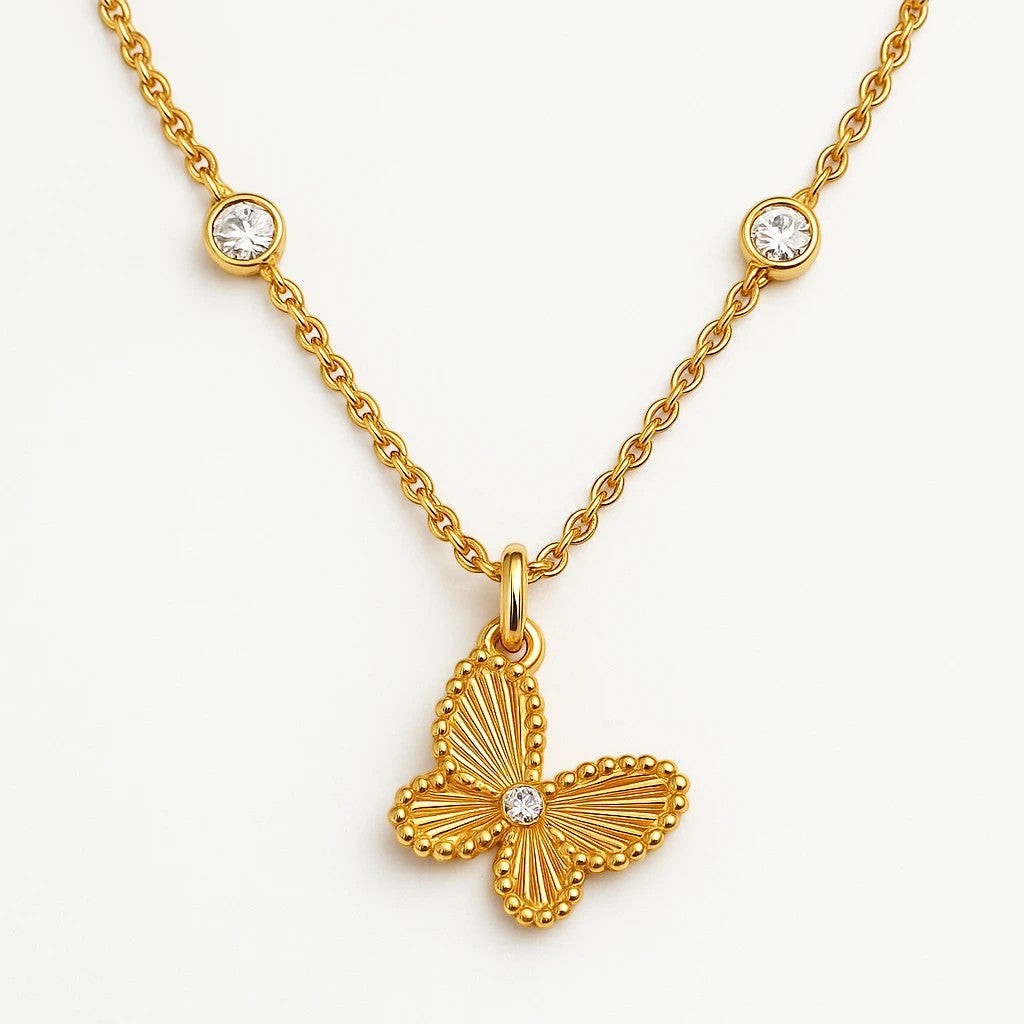The Velvet Grove gold-tone butterfly pendant necklace with textured wings, a central stone, and two bezel-set accents.