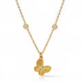 The Velvet Grove gold butterfly pendant necklace with textured wings, a central stone, and two bezel-set chain accents.