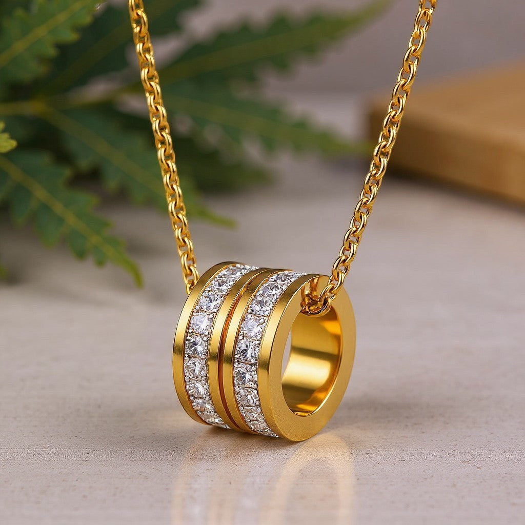 The Velvet Grove gold-tone layered necklace featuring a cylindrical ring pendant with pavé-set crystals