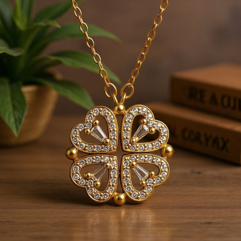 The Velvet Grove gold-tone clover pendant necklace featuring four heart-shaped charms encrusted with sparkling crystals.