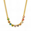 The Velvet Grove gold-tone herringbone chain necklace featuring a row of vibrant, bezel-set multi-colored stones.