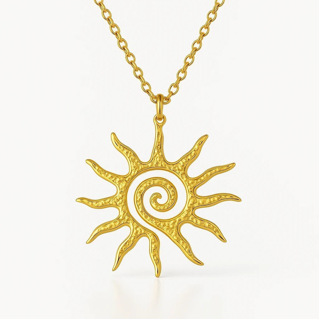 The Velvet Grove gold-tone sun pendant necklace featuring an intricate hammered texture and central spiral design.