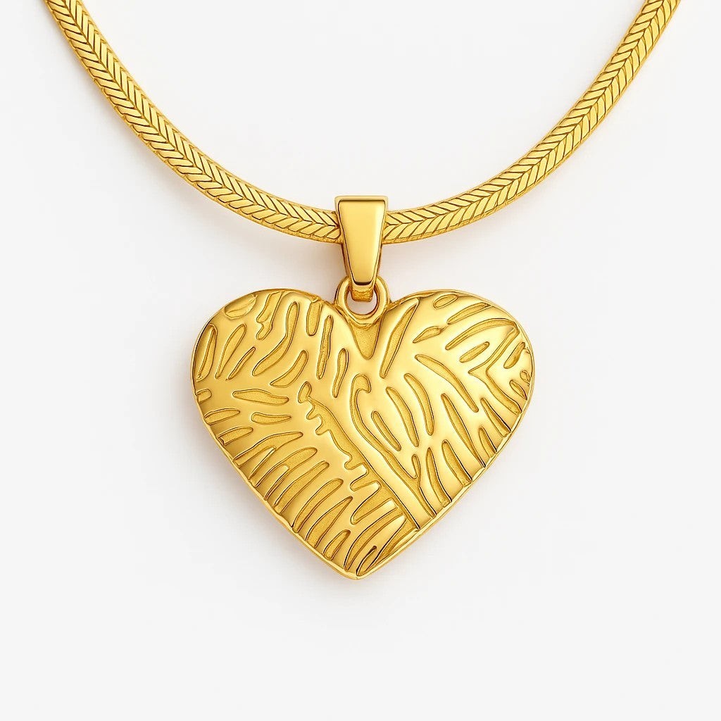 The Velvet Grove 18k gold plated heart pendant necklace with organic textured pattern on a sleek herringbone chain.