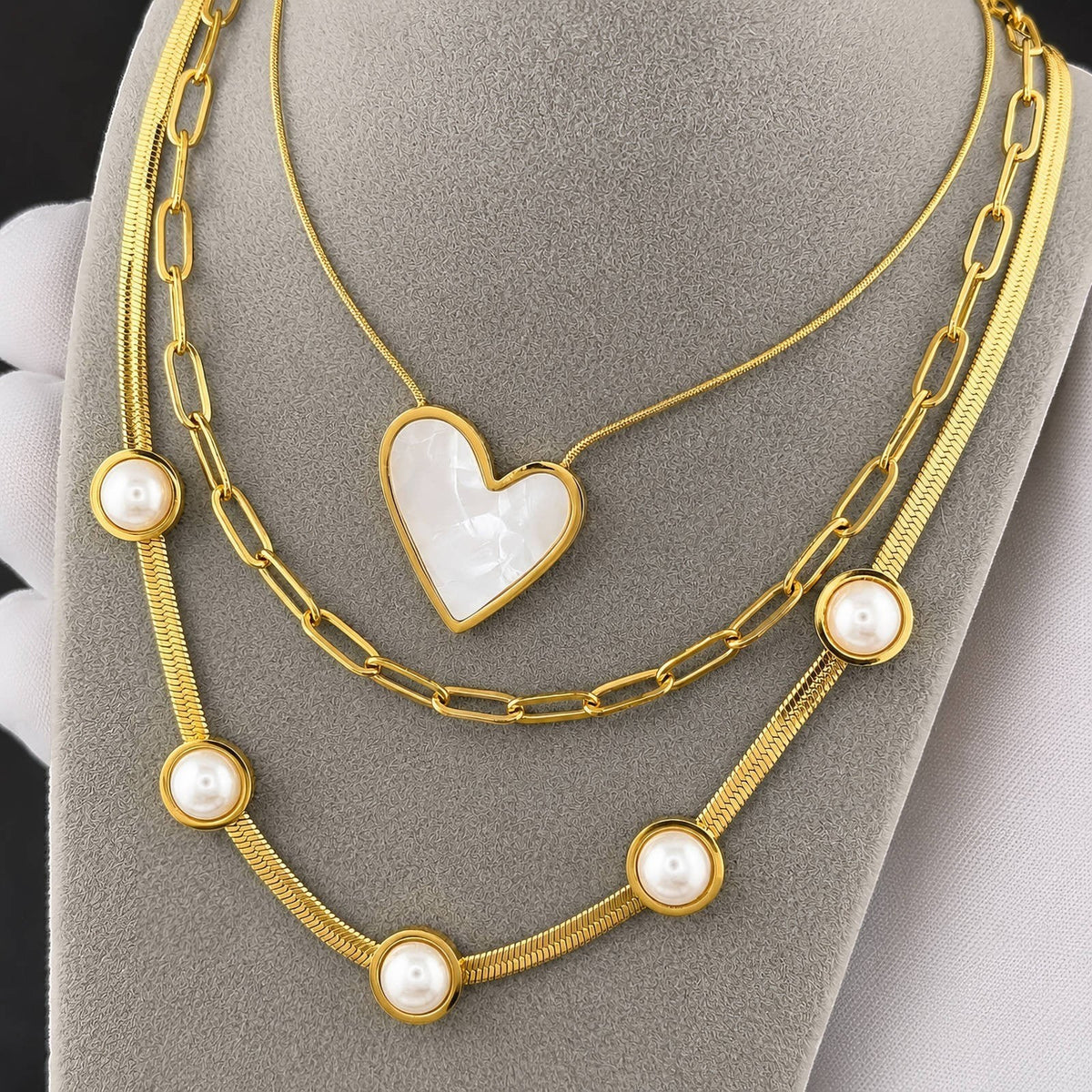 The Velvet Grove layered gold-tone necklace featuring a heart pendant with pearlescent inlay and pearl accents.