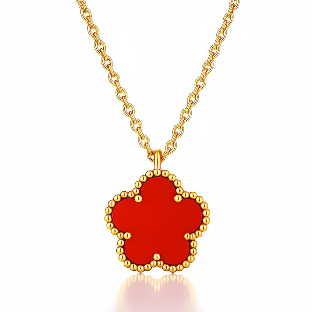 The Velvet Grove red floral pendant necklace featuring a five-petal flower charm with a beaded gold-tone border.