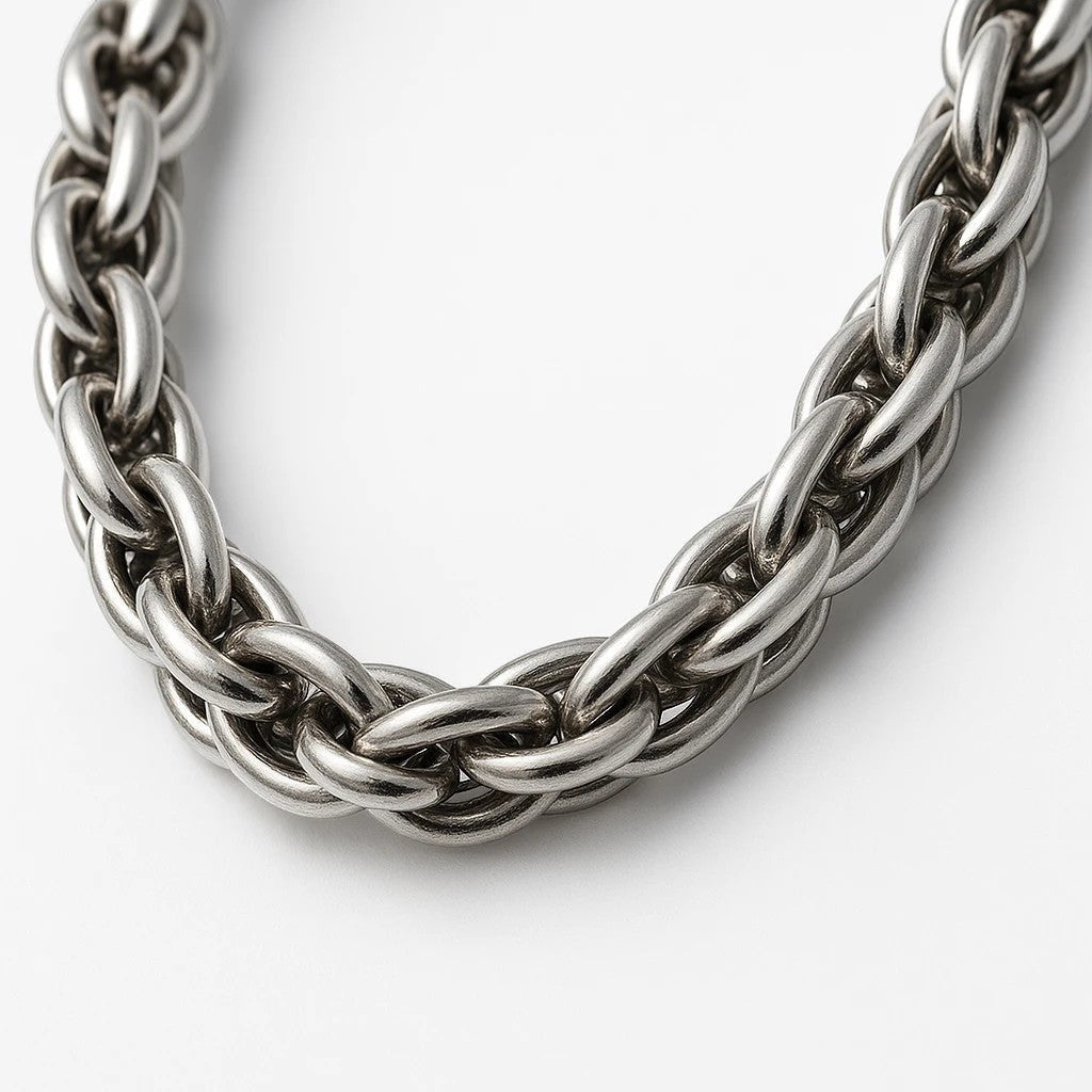 The Velvet Grove silver-tone chunky chain link necklace with a polished metallic finish and intricate woven design.