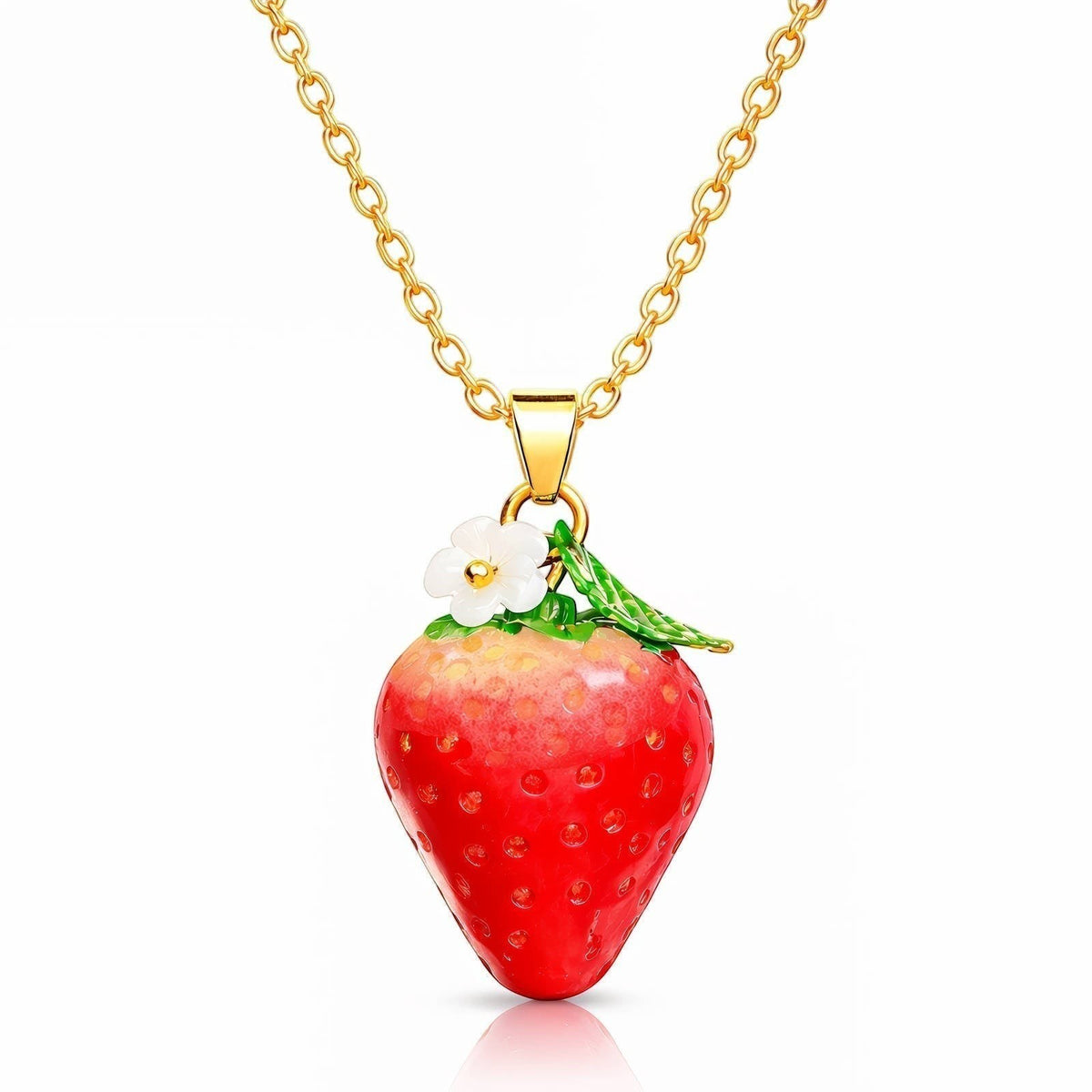 The Velvet Grove strawberry pendant necklace featuring a glossy red fruit with a white flower on a gold-tone chain.