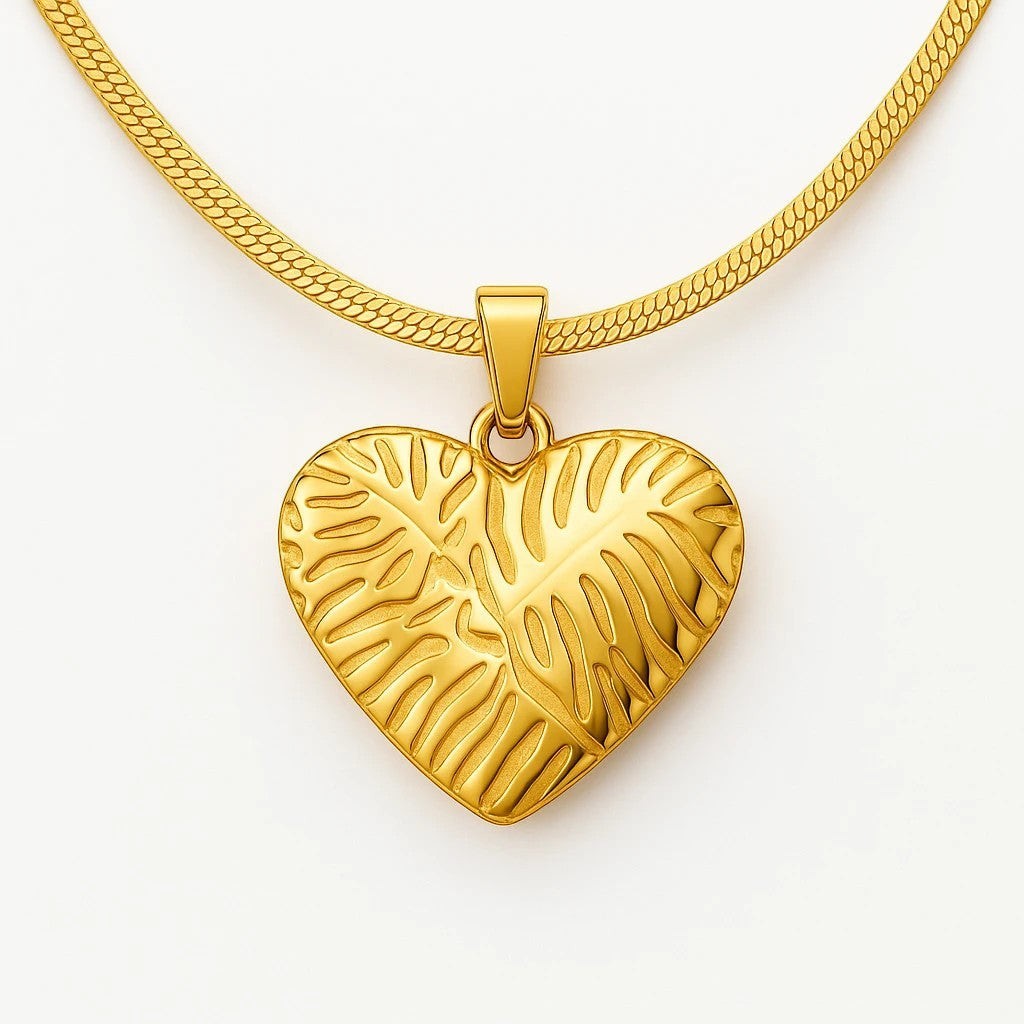 The Velvet Grove 18k gold plated steel heart pendant necklace with organic textured pattern on a herringbone chain.
