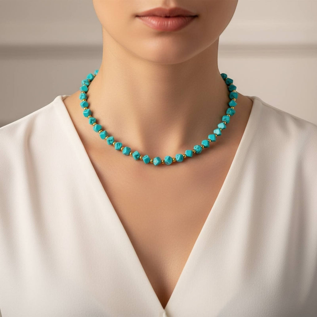 The Velvet Grove beaded statement necklace with turquoise-hued stones and gold-tone accents worn on a model.