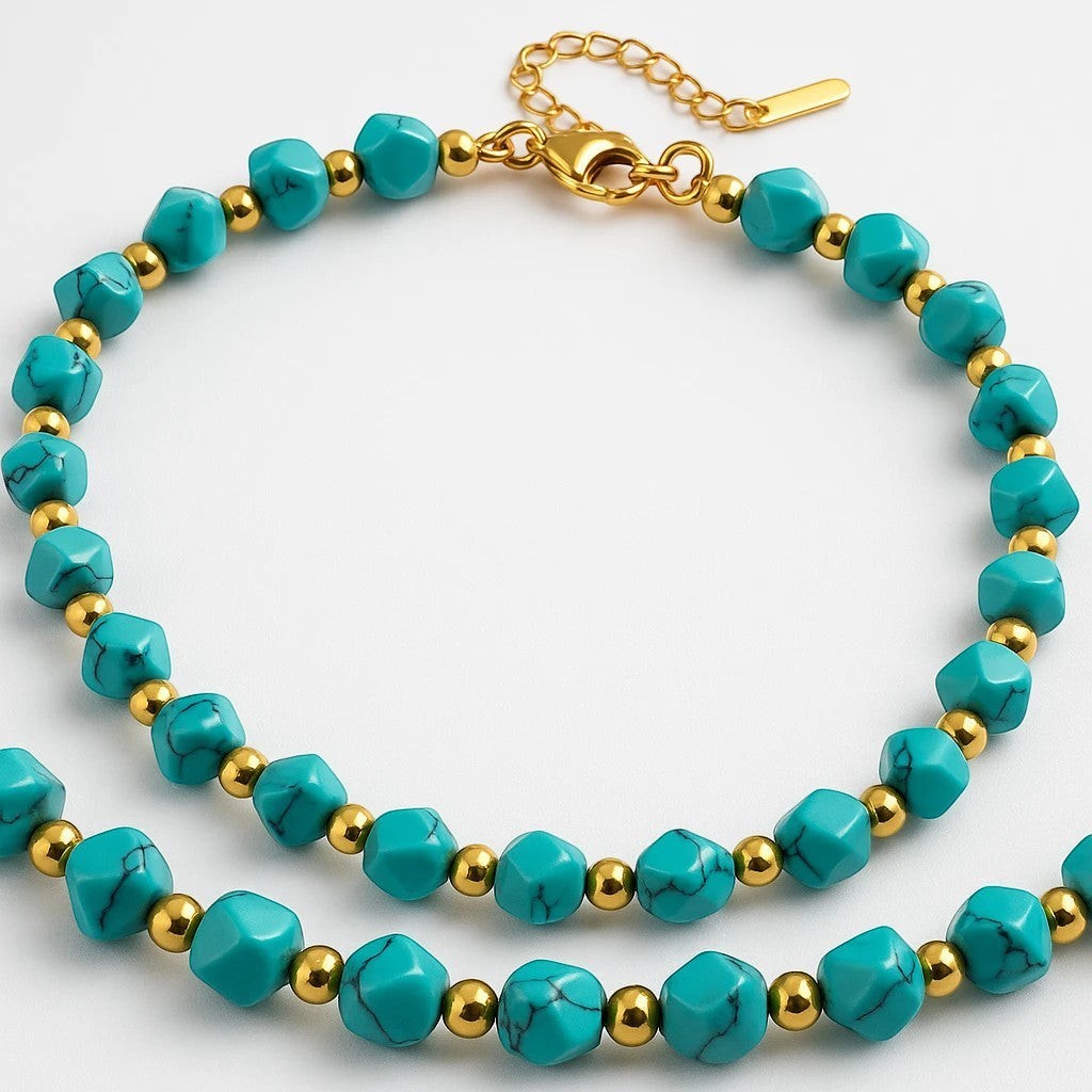The Velvet Grove beaded statement necklace featuring turquoise-hued beads and polished gold-tone accents with adjustable clasp